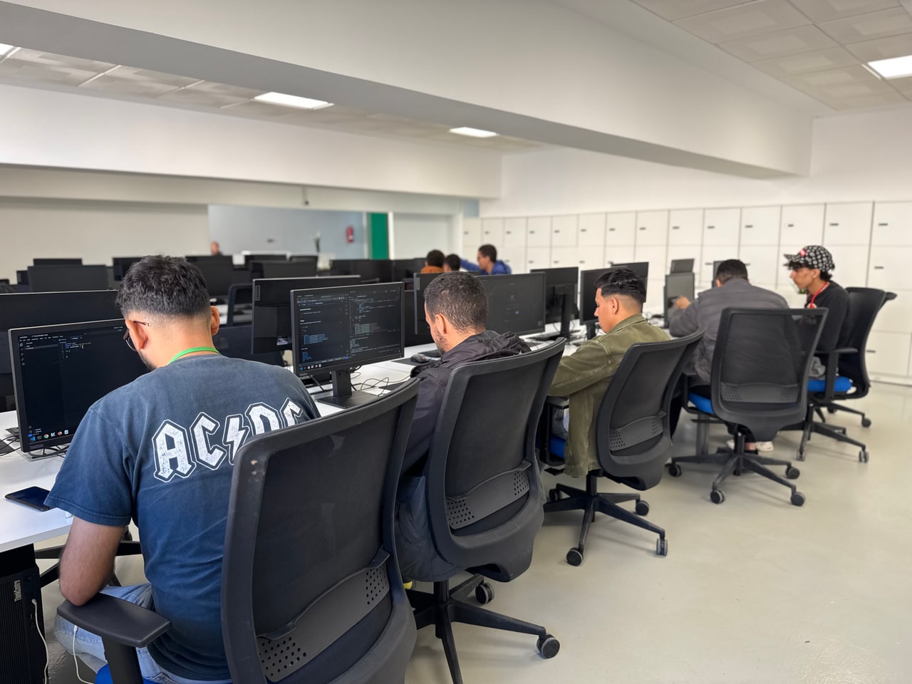 Students focused on coding in a shared workspace